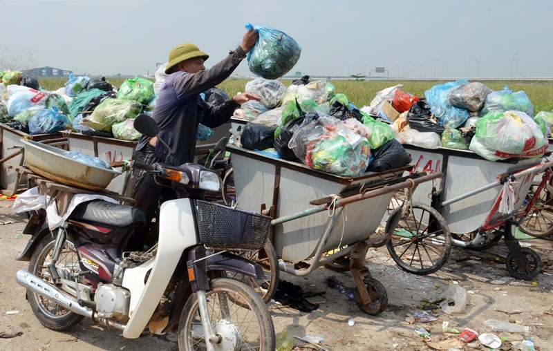 Ông Nguyễn Bá Tành, khu dân cư 14 (phường Hà An) đem rác của gia đình ra điểm tập kết rác của phường tại khu dân cư 11.
