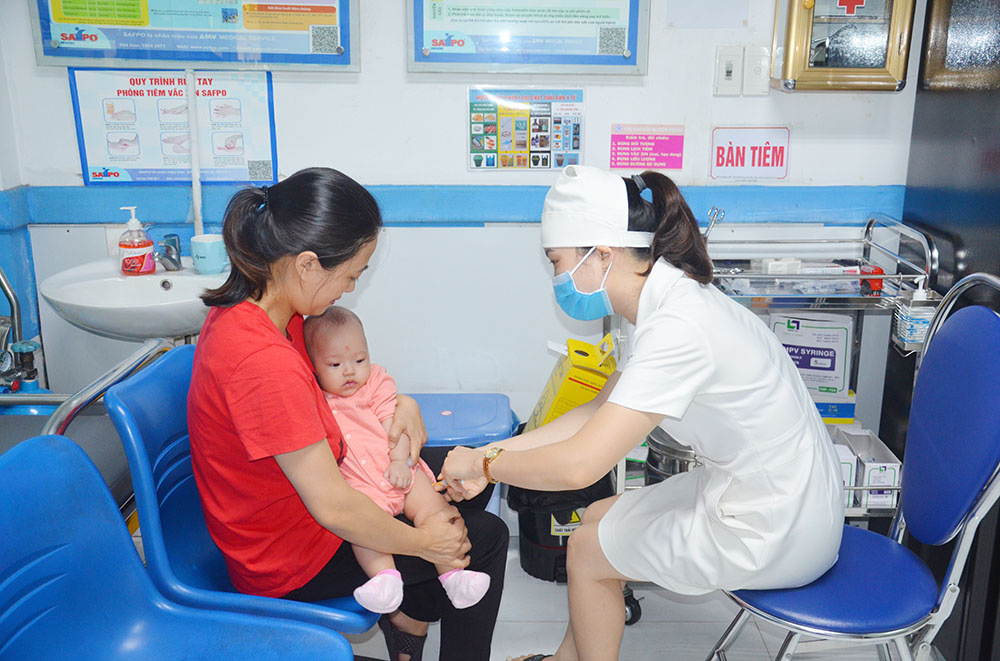 Cán bộ y tế tại Trung tâm Kiểm soát bệnh tật tỉnh tiêm phòng cho trẻ em tại TP Hạ Long.