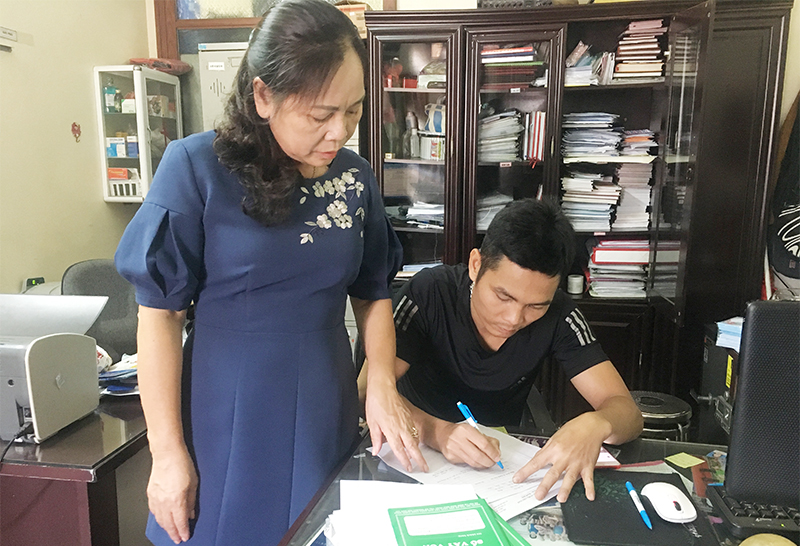 Bà Triệu Thị Châm hướng dẫn người dân khu 6, phường Mông Dương, TP Cẩm Phả làm thủ tục vay vốn tín dụng chính sách