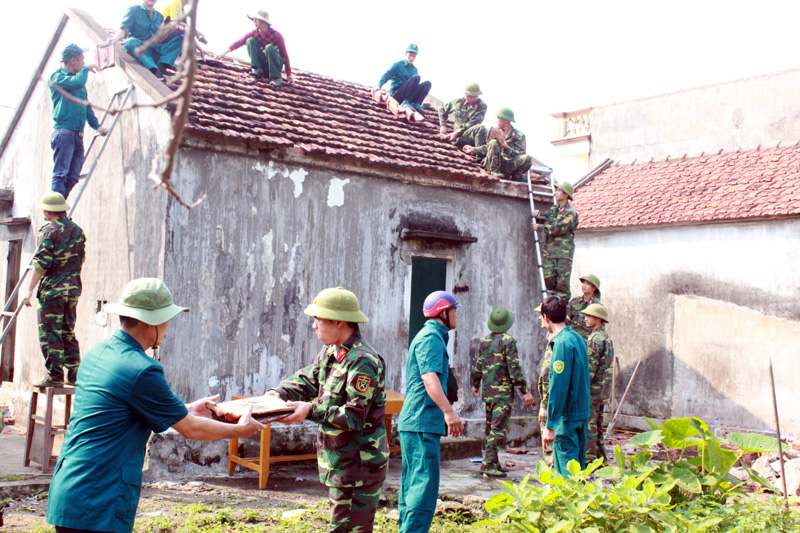 Cán bộ, chiến sĩ LLVT TP Móng Cái hành quân dã ngoại giúp nhân dân sửa chữa nhà cửa. Ảnh do Ban Chỉ huy Quân sự TP Móng Cái cung cấp