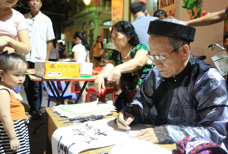Đến với phố đi bộ, người dân và du khách được thưởng thức nhiều hoạt động hấp dẫn. Trong ảnh: Ông đồ già viết thư pháp.