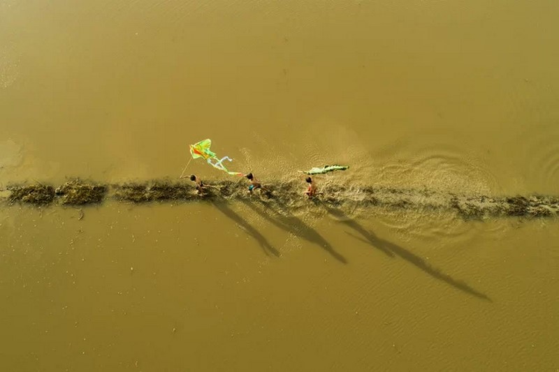 Trẻ em thả diều trên đồng mùa ngập nước ở Đồng bằng sông Cửu Long. Ảnh: Thien Nguyen.