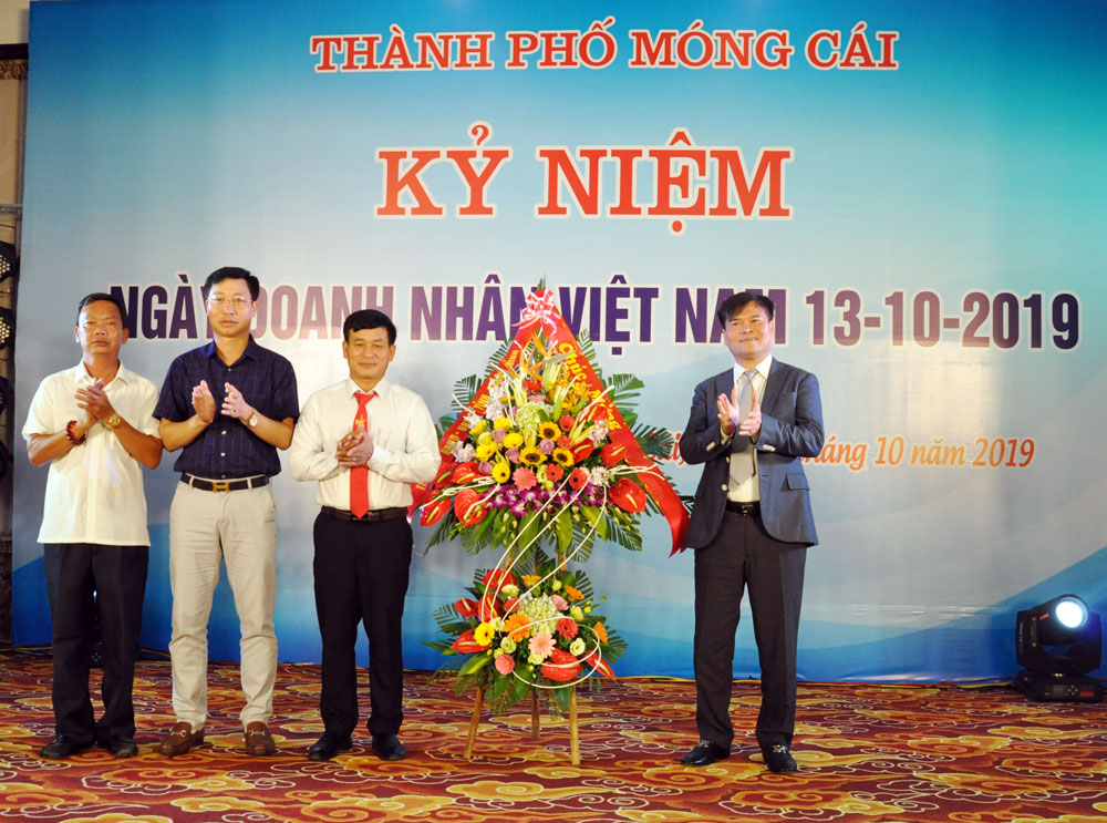 Đồng chí Bùi Văn Khắng, Phó Chủ tịch UBND tỉnh tặng hoa chúc mừng các doanh nhân thành phố Móng Cái.