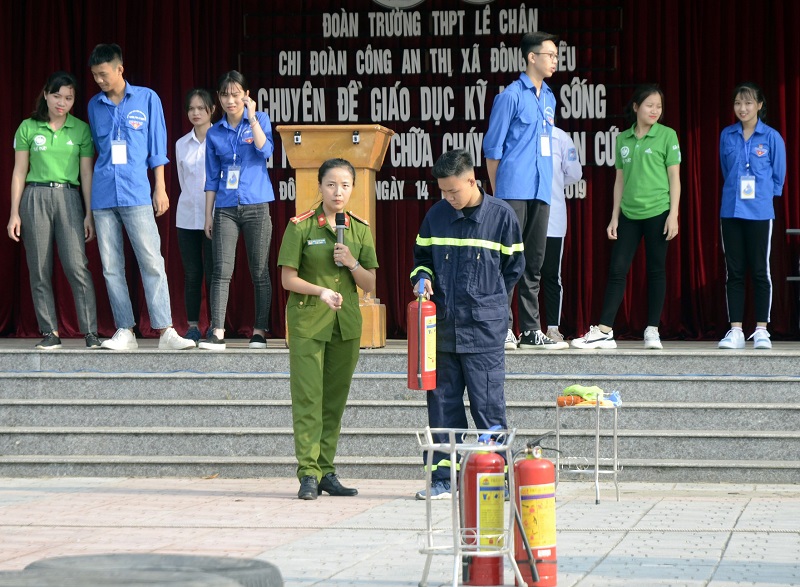 cán bộ PCCC (Công an TX Đông Triều) hướng dẫn kỹ năng sử dụng bình chữa cháy để chữa cháy cho thầy và trò Trường THPT 