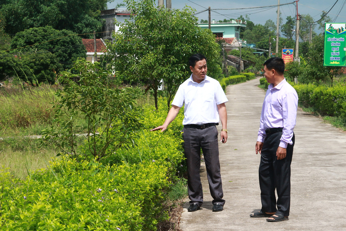 Lãnh đạo UBND xã Quảng Chính tham gia với người dân thôn 7 về cách thức trồng, chăm sóc cây xanh trồng ven đường trục thôn.