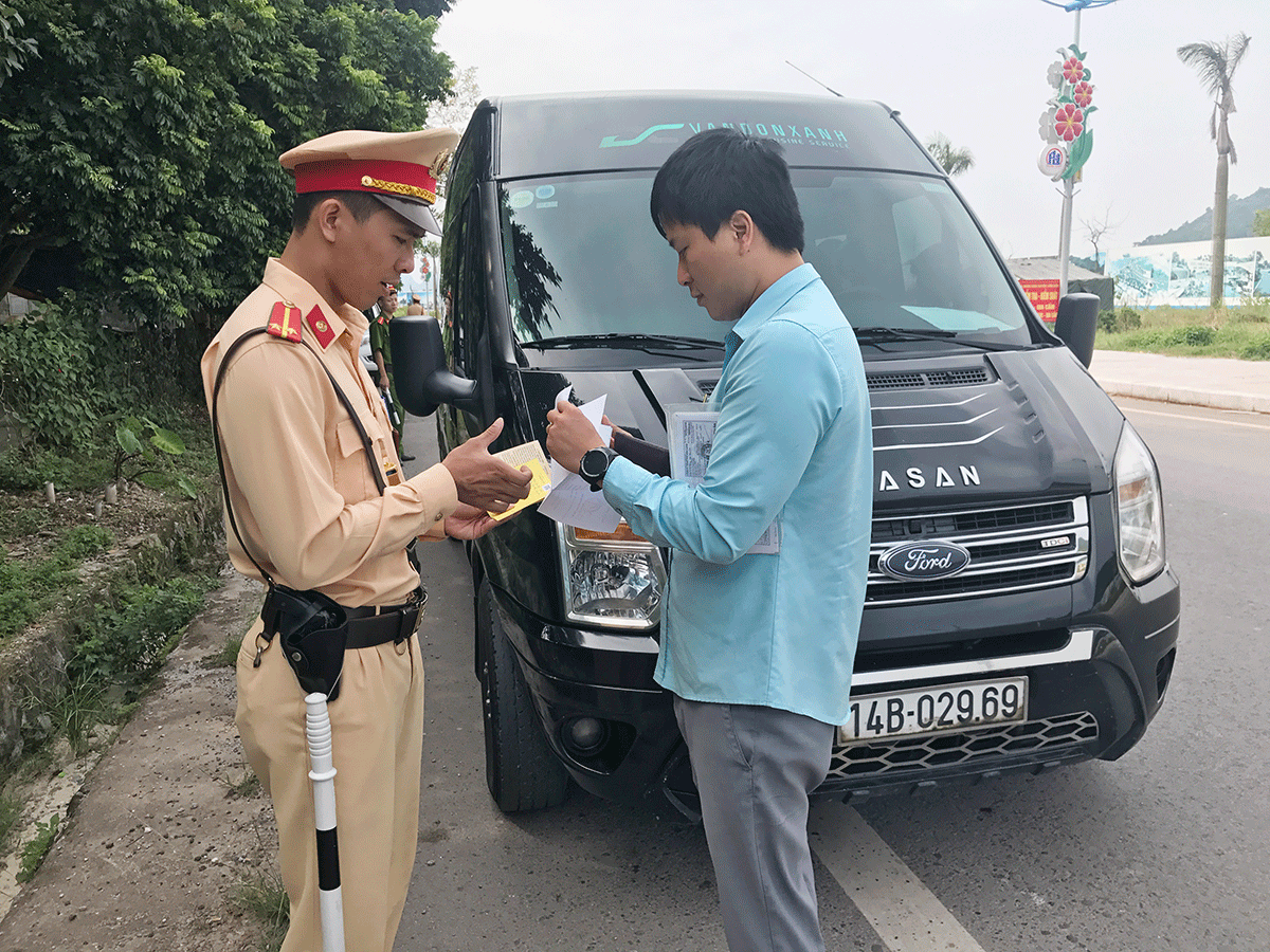 Cán bộ đội CSGT Công an huyện Vân Đồn kiểm tra hành chính phương tiện xe khách lưu thông trên địa bàn 