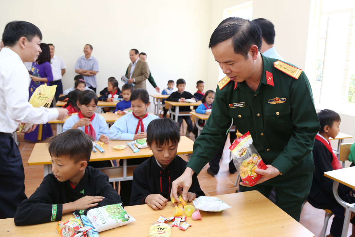 Đại tá Nguyễn Quang Hiến, Phó Chính ủy Bộ CHQS tỉnh, cùng các đại biểu tham quan phòng học mới và tặng quà cho các cháu học sinh.