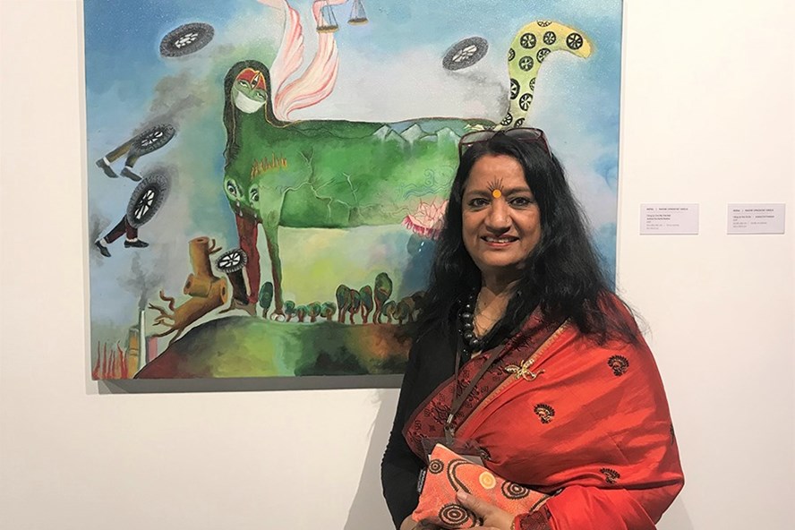 Nữ họa sĩ duy nhất được chọn cho triển lãm, bà Ragini Upadhyay Grela từ Nepal bên tác phẩm của bà. Ảnh: VIỆT VĂN
