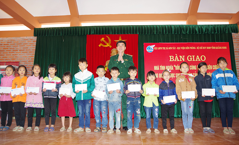 Đại tá Nguyễn Thái Sinh, Phó Chính ủy Học viện biên phòng Việt Nam tặng quà cho các cháu học sinh.