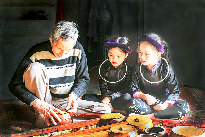 Nghệ nhân Lương Thiên Phú (huyện Bình Liêu) truyền lửa đam mê nghệ thuật đàn tính cho các cháu nhỏ. Ảnh Hoàng Gái (trung tâm TTVH Bình Liêu)
