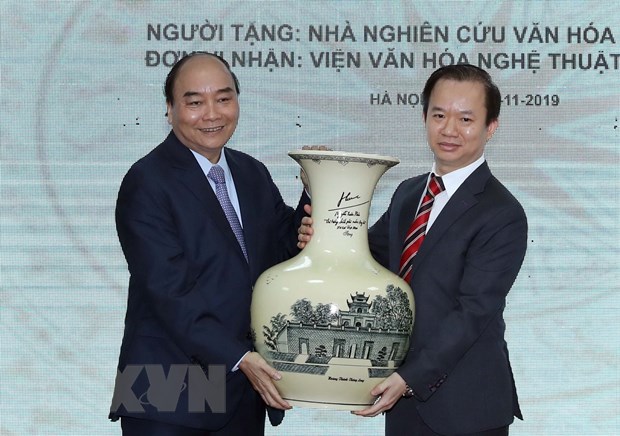 Thủ tướng Nguyễn Xuân Phúc tặng quà lưu niệm Viện Văn hóa nghệ thuật Quốc gia Việt Nam. (Ảnh: Thống Nhất/TTXVN)