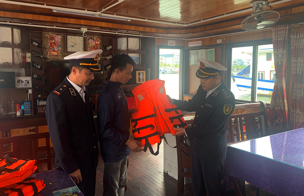 Cán bộ Cảng vụ đường thủy nội địa kiểm tra thiết bị áo phao an toàn trên phương tiện vận chuyển hành khách đi tham quan Vịnh Hạ Long 
