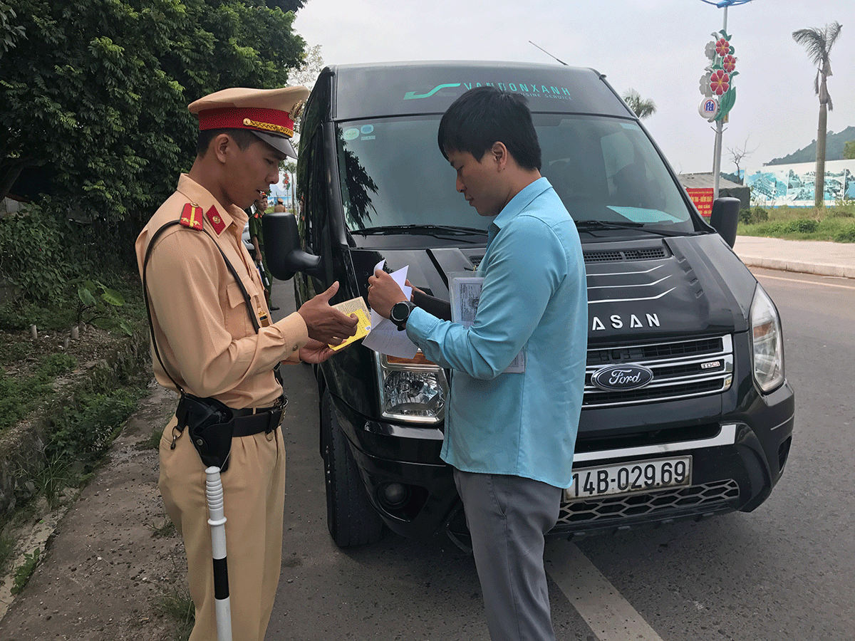 Cán bộ đội CSGT Công an huyện Vân Đồn kiểm tra hành chính phương tiện xe khách lưu thông trên địa bàn
