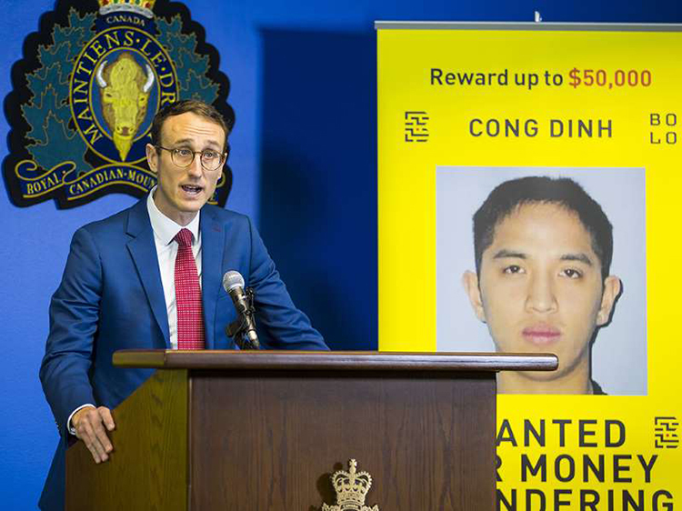 Ông Maxime Langlois, thuộc dự án BOLO Program, tuyên bố treo thưởng 50.000 CAD để truy bắt Cong Dinh (ảnh phía sau) hôm 3/12 tại Vancouver, Canada. Ảnh: Vancouver Sun