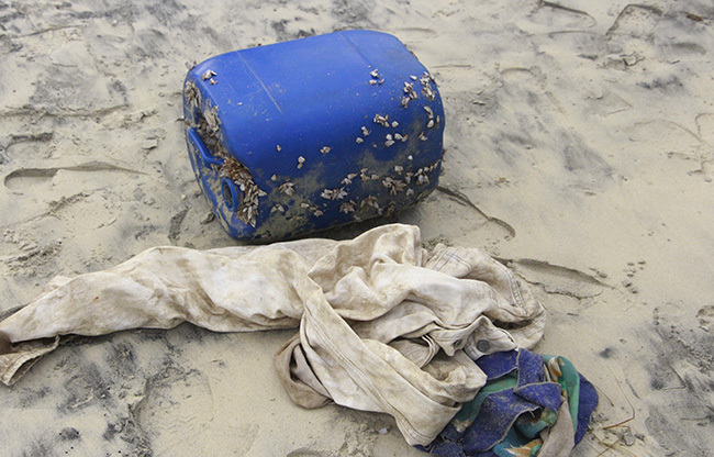 Can nhựa chứa heroin và áo quần dạt vào bờ biển do ông Lộc nhặt được. Ảnh: Võ Thạnh
