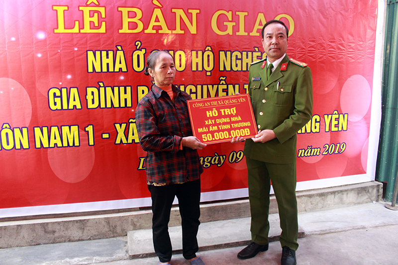 Thượng tá  Vũ Xuân Lịch, Trưởng công an thị xã Quảng Yên trao hỗ trợ cho bà Nguyễn Thị Hòa