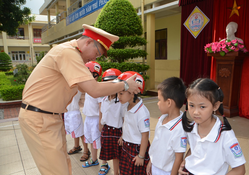 Đội CSGT- TT Công an TP Móng Cái tuyên truyền luật giao thông, trao tặng mũ bảo hiểm đạt chuẩn cho học sinh lớp 1 Trường TH Lý Tự Trọng.