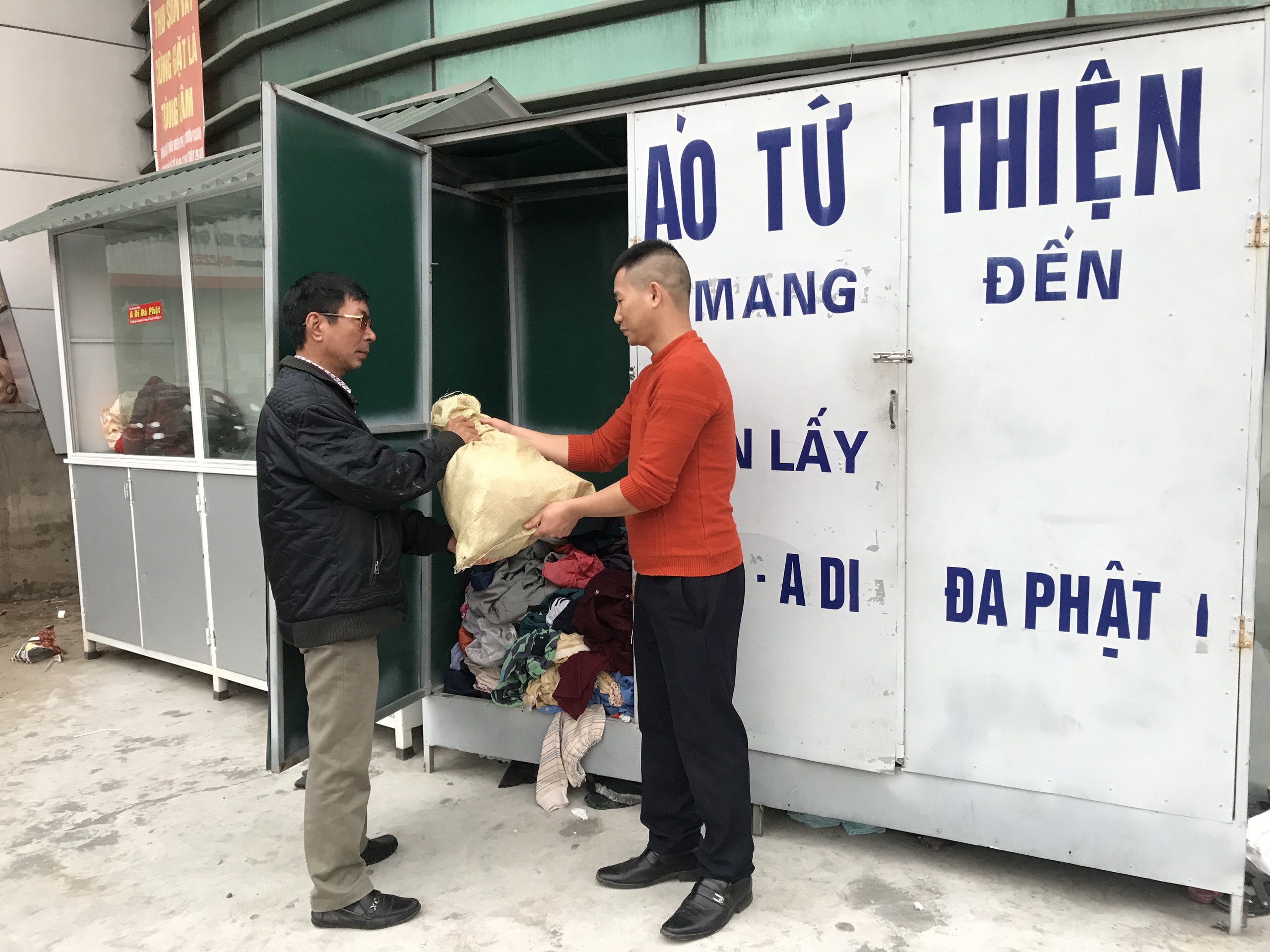 Người dân mang quần áo để tủ quần áo từ thiện ở chợ Hồng Hà để quyên góp. 