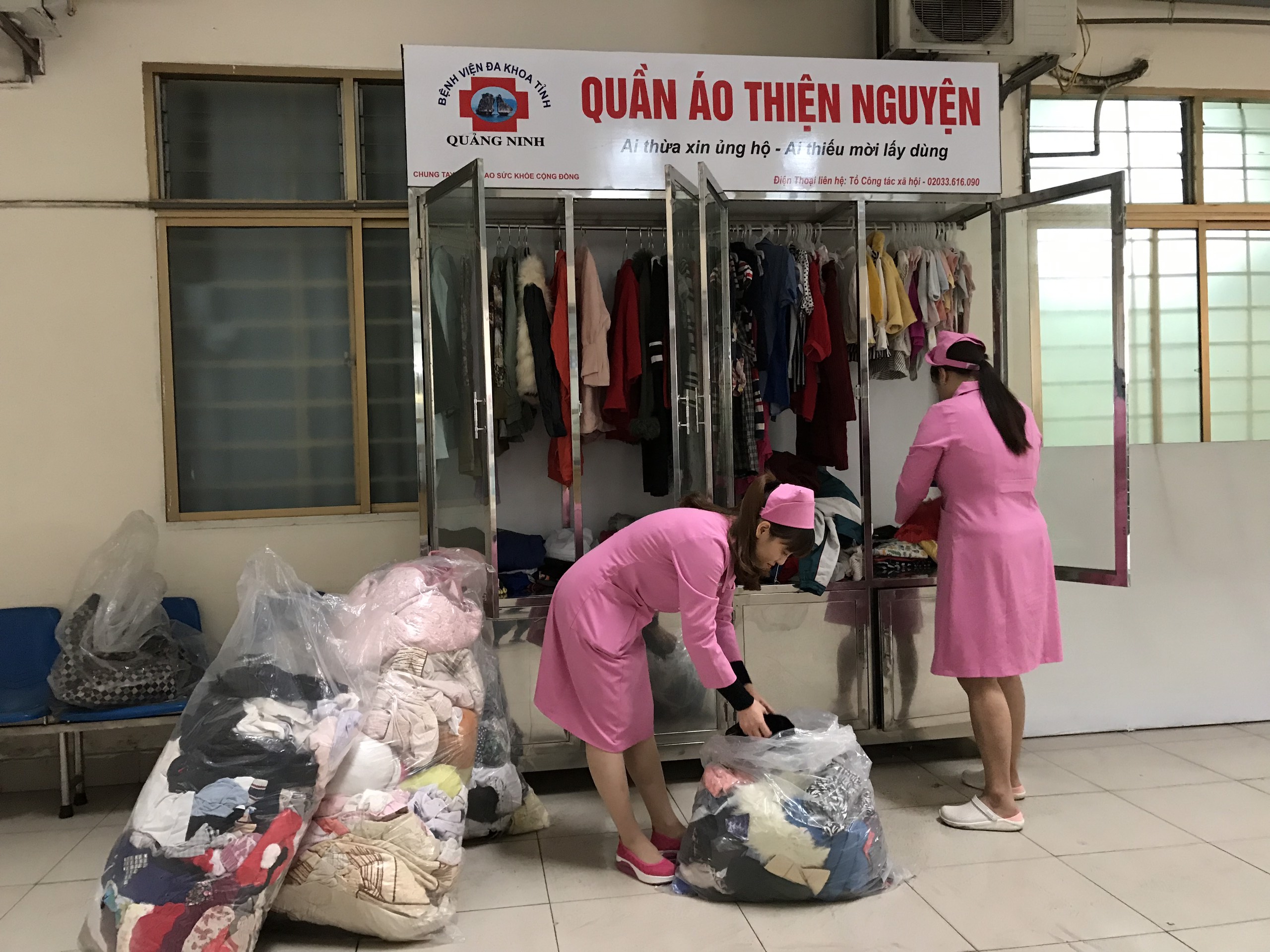 Các thành viên Tổ Công tác xã hội, Bệnh viện Đa khoa tỉnh sắp xếp quần áo tại tủ quần áo từ thiện. 