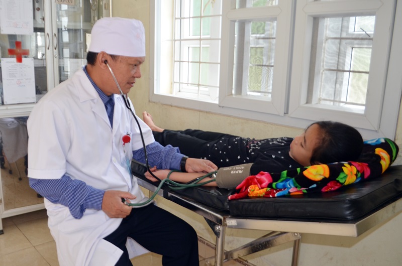 Bác sĩ Ngô Văn Vinh, Trạm trưởng Trạm y tế xã Nam Sơn (huyện Ba Chẽ) kiểm tra sức khỏe cho học sinh trên địa bàn.