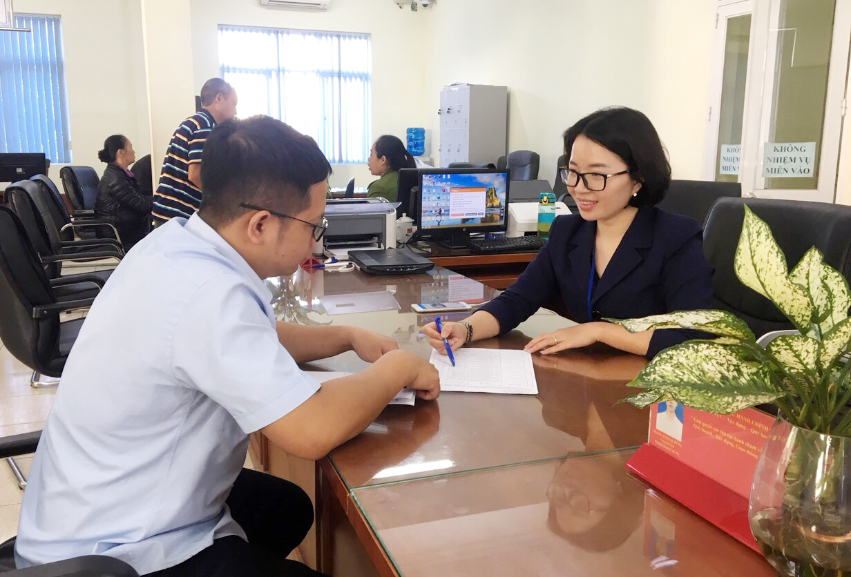 Cán bộ, công chức làm việc tại Trung tâm Hành chính công TP Cẩm Phả hướng dẫn, giải quyết TTHC cho công dân, tháng 12/2019.