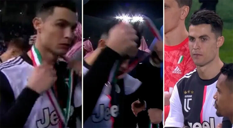 Ronaldo tháo huy chương khi còn đứng trên bục nhận giải.