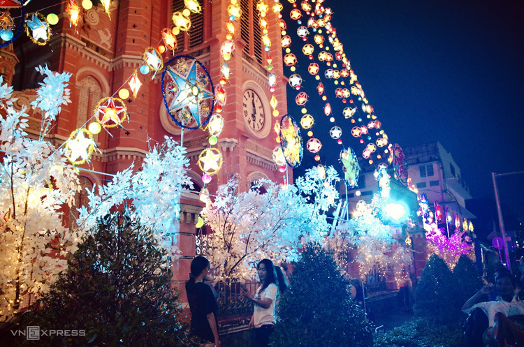 Dàn đèn nhiều màu sắc được giăng từ đỉnh tháp chuông xuống cổng chính, kết hợp với những cành cây trắng như phủ tuyết tạo nên khung cảnh huyền ảo, thu hút nhiều khách tham quan và chụp ảnh vào buổi tối.