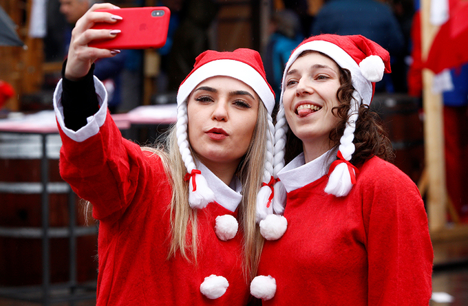 Hai cô gái mặc đồng phục Noel chụp ảnh selfie khi tham gia cuộc thi chạy thường niên của thành phố Skopje, Macedonia hôm 22/12.