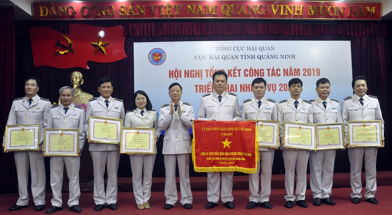 Đồng chí Nguyễn Văn Nghiên, Cục trưởng Cục HQQN trao cờ và băng khen của UBND tỉnh cho các tập thể.