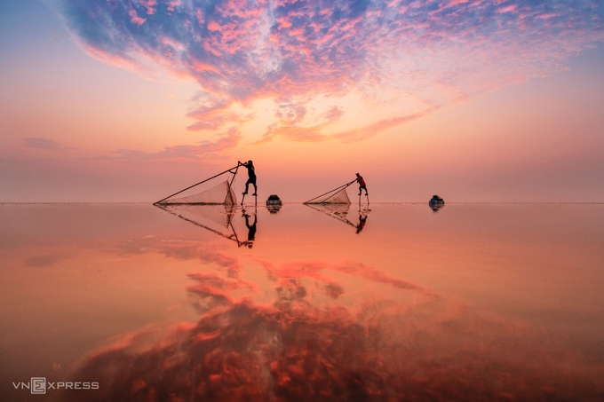 Tác phẩm “Bình minh trên biển” chụp những người đàn ông đi trên chiếc cà kheo bằng tre cao khoảng một mét, kết hợp với lưới để bắt cá tôm nhỏ tại bãi biển Quang Lang thuộc xã Thụy Hải, huyện Thái Thụy, tỉnh Thái Bình.