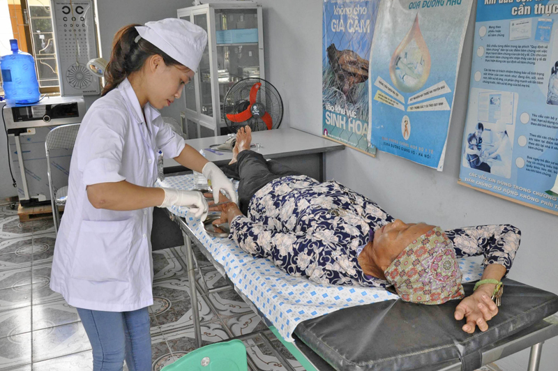 Xử lý, băng bó vết thương cho người dân tại Trạm y tế xã Quảng Sơn, huyện Hải Hà