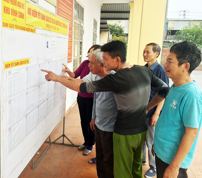 Người dân khu phố Vĩnh Sinh, phường Mạo Khê (TX Đông Triều) theo dõi danh sách cử tri sau khi được niêm yết.