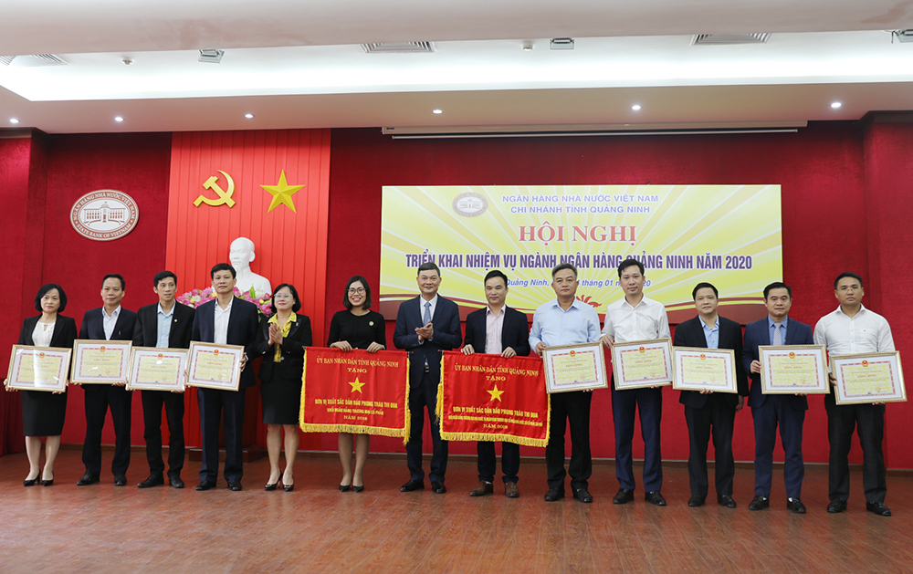 Lãnh đạo NHNN Chi nhánh Quảng Ninh trao Cờ và Bằng khen của UBND tỉnh cho các đơn vị có thành tích xuất sắc.