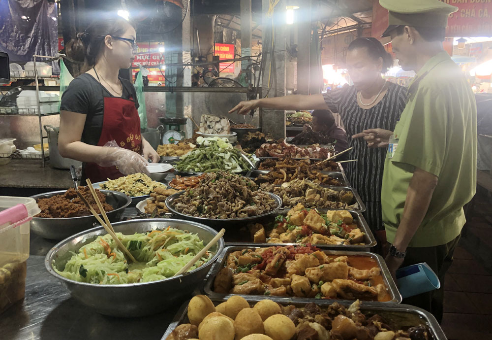 Hầu hết thức ăn đường phố không được che đậy. Ảnh: Một hộ kinh doanh thức ăn chế biến sẵn tại chợ Hạ Long 2. Tháng 12/2019
