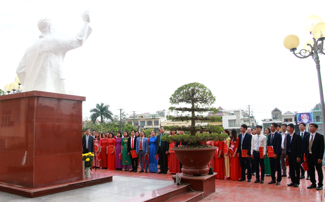 Các đại biểu và 24 quần chúng ưu tú được kết nạp Đảng thực hiện nghi lễ chào cờ trước tượng đài Bác Hồ.