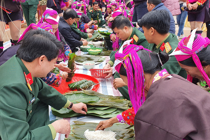 Cán bộ, chiến sĩ Ban CHQS huyện Tiên Yên phối hợp gói bánh chưng tặng cho các hộ dân Khu tái định cư bản Nà Cà.