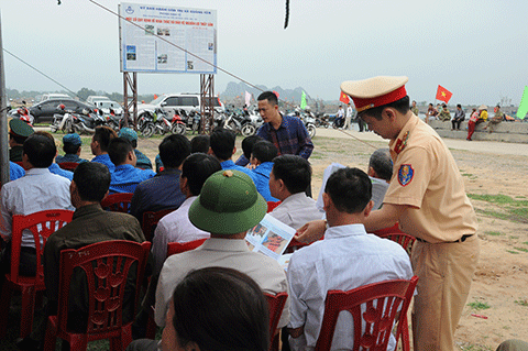 Cán bộ Phòng CSGT đường thủy Công an tỉnh và Ban ATGT phát tờ rơi tuyên truyền Luật giao thông cho người dân TX Quảng Yên