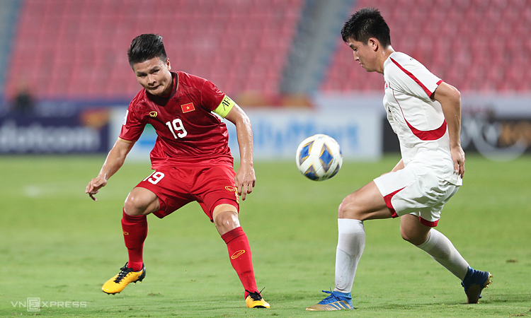 Quang Hải (trái) chuyền bóng trong trận đấu với Triều Tiên tối 16/1. Ảnh: Đức Đồng.