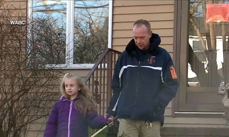 Bé gái Madalyn và bố bên ngoài ngôi nhà bị cháy của họ ở bang New Jersey hôm 19/1. Ảnh: ABC.