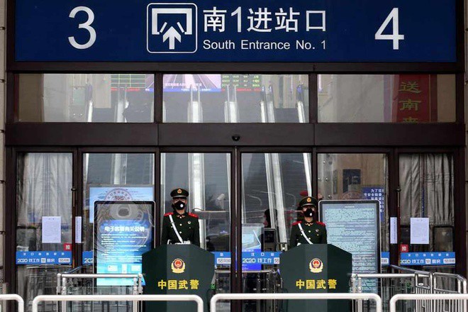 Các sĩ quan bán quân sự Trung Quốc đeo mặt nạ bảo vệ ở lối vào của nhà ga Hankou đã đóng cửa sau khi thành phố bị phong tỏa ở Vũ Hán, tỉnh Hồ Bắc, Trung Quốc, ngày 23/1. Ảnh: Reuters