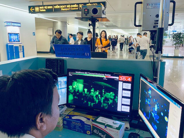 Kiểm tra thân nhiệt hành khách nhập cảnh qua sân bay quốc tế Tân Sơn Nhất, TP HCM. Ảnh: Duy Tính.