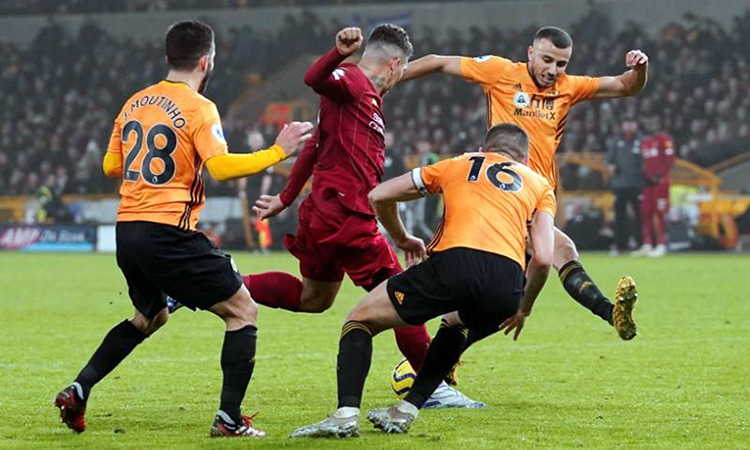 Firmino (áo đỏ) xoay sở giữa vòng vây hàng thủ Wolves. Ảnh: Reuters.