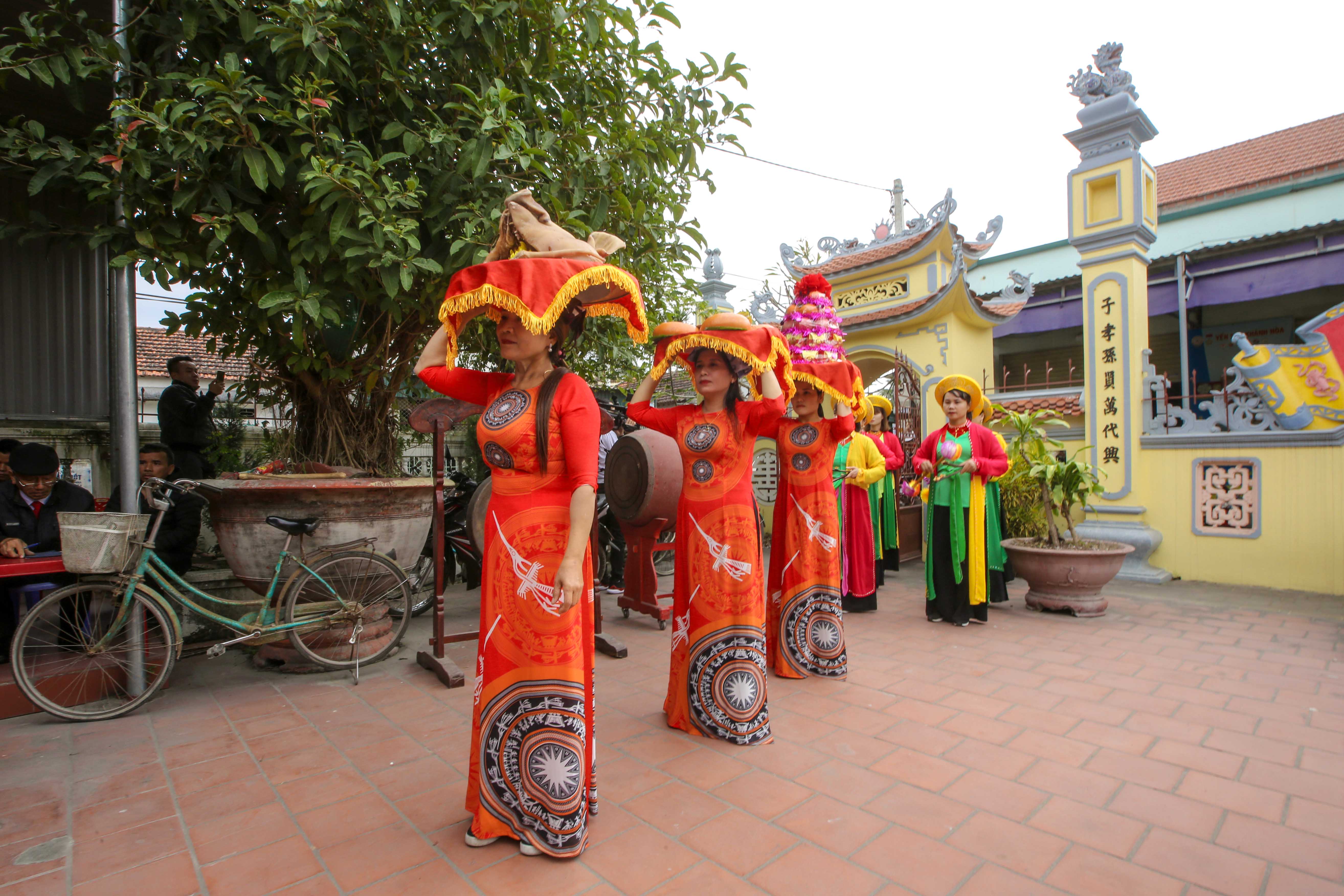 Families carry ritual offerings on heads