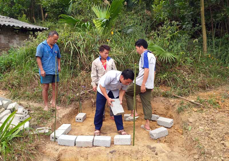Đồng chí Bàn Văn Vy cùng Chi đoàn Thanh niên thôn Khe Phương giúp người dân trong thôn làm công trình phụ
