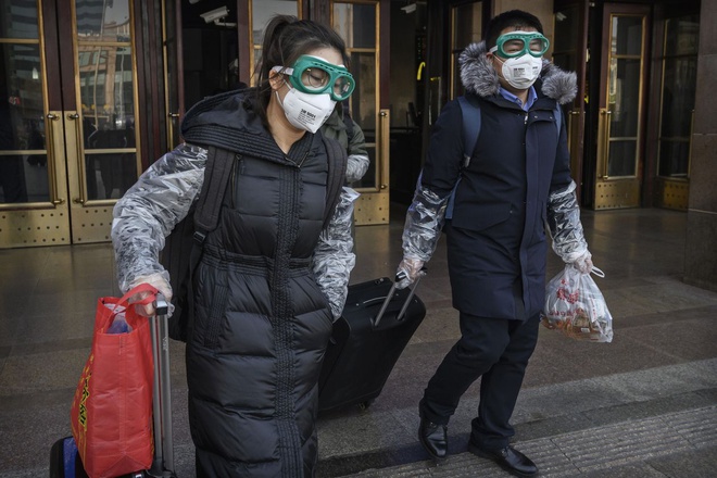 Người Trung Quốc đeo kính và mặt nạ sau khi trở về Bắc Kinh từ kỳ nghỉ Tết Nguyên đán. Ảnh: Getty.