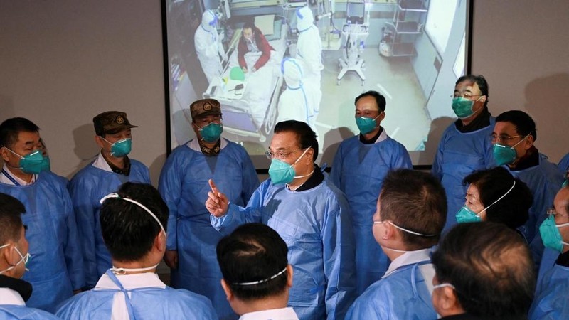 Thủ tướng Trung Quốc Lý Khắc Cường đeo mặt nạ và bộ đồ bảo hộ nói chuyện với các nhân viên y tế tại một bệnh viện có bệnh nhân nhiễm virus ở Vũ Hán, ngày 27/01/2020. Ảnh: Reuters.
