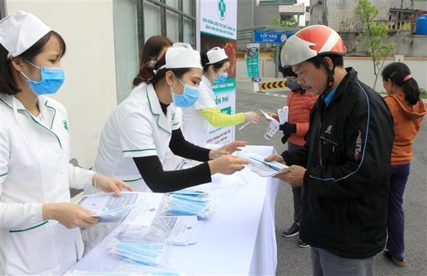 Phát khẩu trang miễn phí cho người dân tại Bệnh viện Đa khoa tỉnh Thái Bình. (Ảnh: Thế Duyệt/TTXVN)