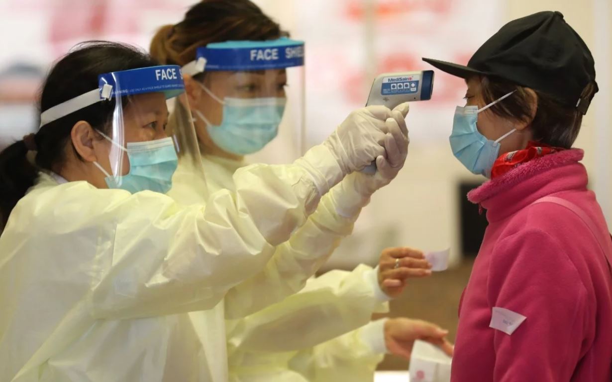 Nhân viên y tế tại Hong Kong (Trung Quốc) kiểm tra thân nhiệt cho người dân. Ảnh: SCMP