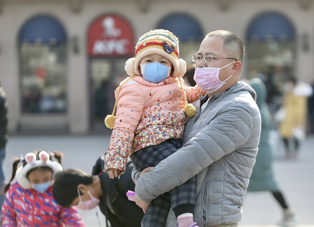 Bé gái và bố đeo khẩu trang tại nhà ga Bắc Kinh ngày 21/1/2020. (Nguồn: Chinadaily)