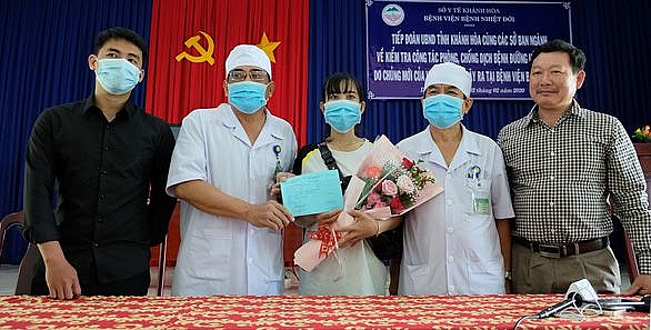 Lãnh đạo Bệnh viện Bệnh nhiệt đới Khánh Hòa và Trung tâm Kiểm soát dịch bệnh Khánh Hòa tặng hoa mừng bệnh nhân H. xuất viện. (Nguồn: Tuổi trẻ)